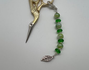 Green beads with a leaf charm scissor accessory