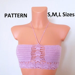 May include: A pink crocheted halter top with a cutout design. The top is displayed on a mannequin and the text "PATTERN S,M,L Sizes" is visible above the top.