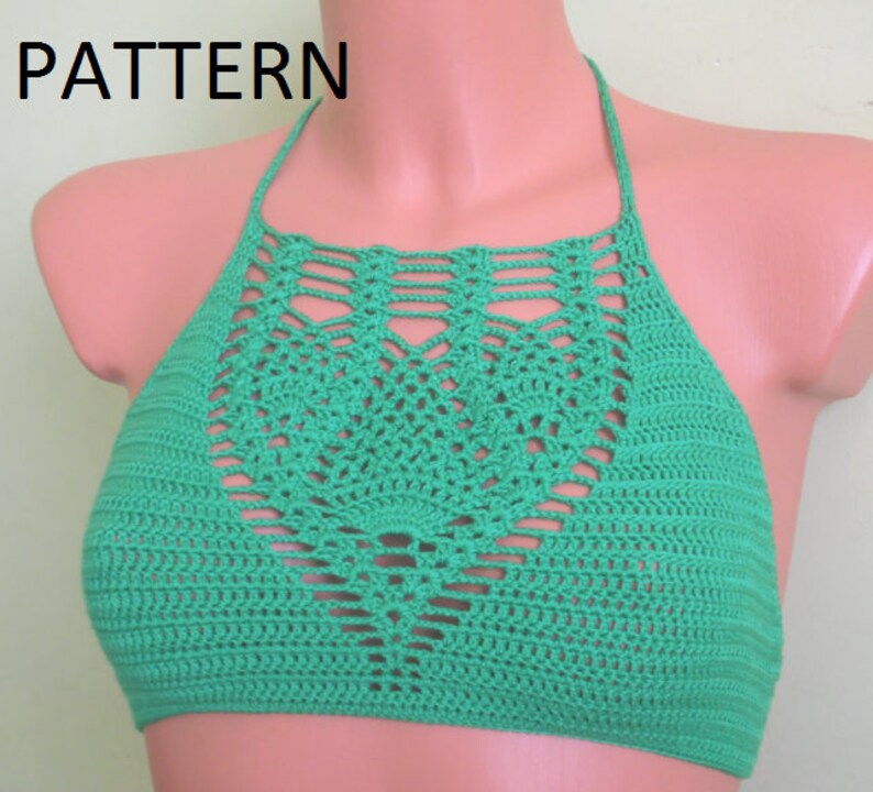 May include: A green crochet halter top with a decorative openwork design on the front. The word "PATTERN" is in the upper left corner. The top is displayed on a mannequin.