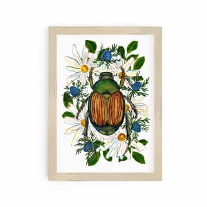 May include: A framed watercolor print featuring a detailed illustration of a beetle with a green head and brown body, surrounded by white daisies, blue berries, and green leaves. The artwork is set against a white background.