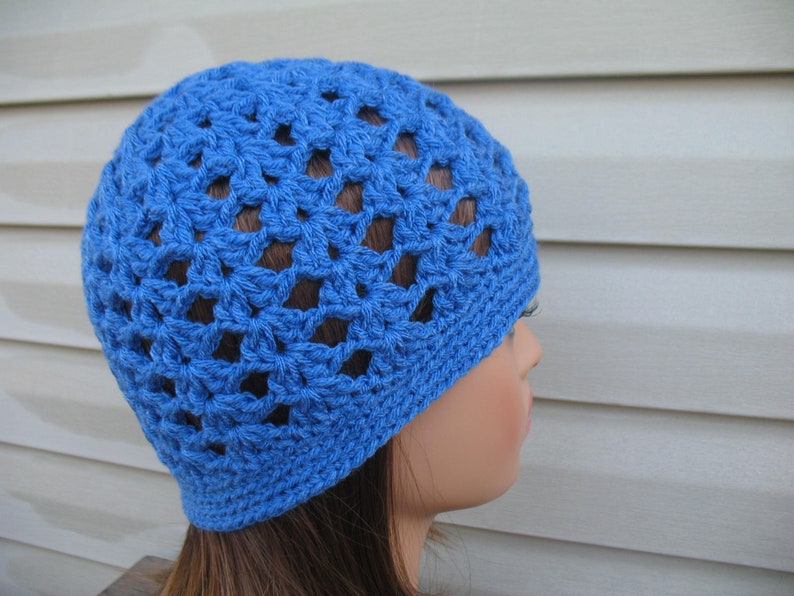 Peut inclure: Un bonnet en crochet bleu avec un motif ajour&eacute;. Le bonnet est fait d'un fil doux et a une coupe confortable.