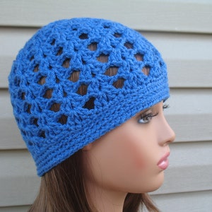 Peut inclure: Un bonnet en crochet bleu avec un motif ajour&eacute;. Le bonnet est fait d'un fil doux et a une coupe confortable.