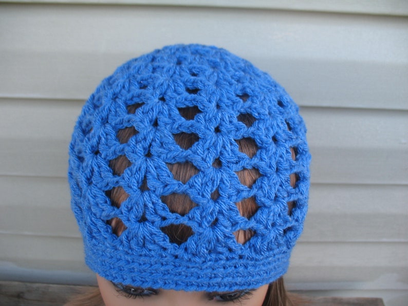 Peut inclure: Un bonnet en crochet bleu avec un motif ajour&eacute;.