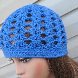 Peut inclure: Un bonnet en crochet bleu avec un motif ajour&eacute;. Le bonnet est fait d'un fil doux et a une coupe confortable.