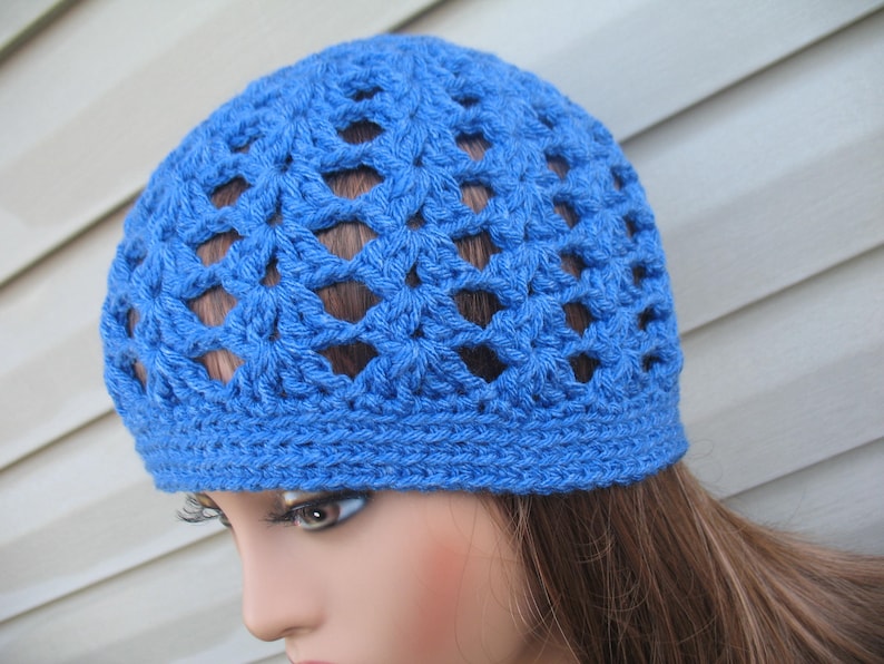 Peut inclure: Un bonnet en crochet bleu avec un motif ajour&eacute;. Le bonnet est fait d'un fil doux et a une coupe confortable.
