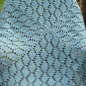 May include: A light blue crocheted blanket with a diamond pattern. The blanket is draped over a wooden chair.