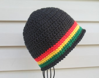 Puede incluir: Gorro de punto negro con una franja roja, amarilla y verde.