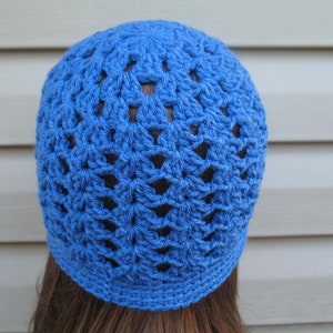 Peut inclure: Un bonnet en crochet bleu avec un motif ajour&eacute;.