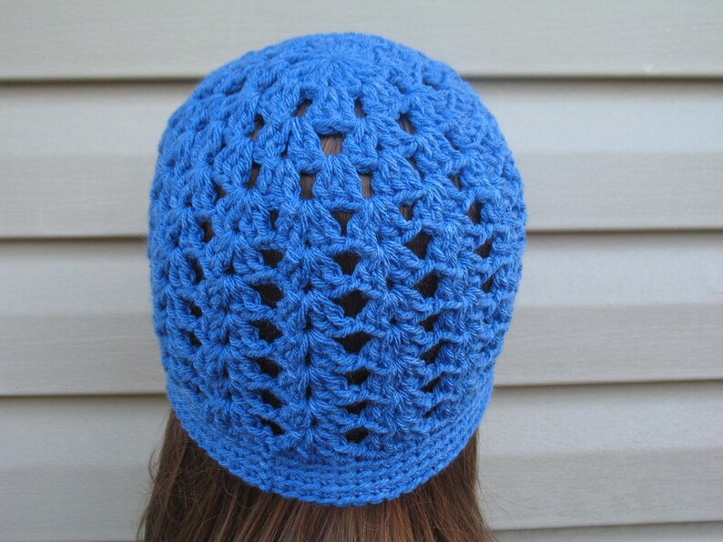 Peut inclure: Un bonnet en crochet bleu avec un motif ajour&eacute;.