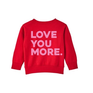 May include: Red sweatshirt with long sleeves and a pink graphic that says "LOVE YOU MORE."