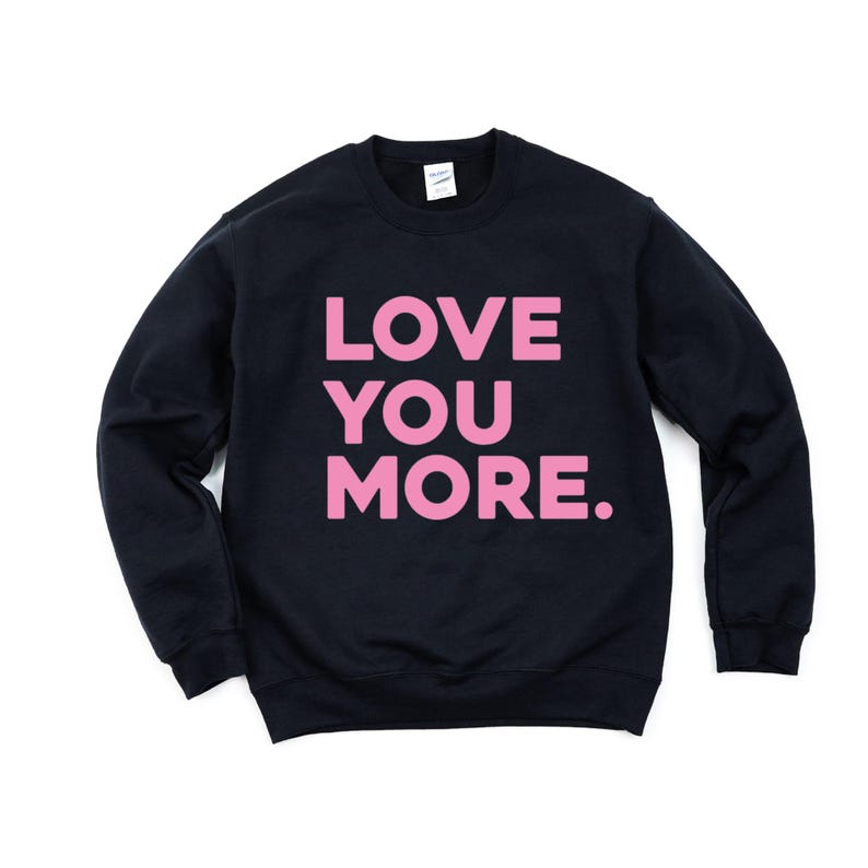 May include: Black sweatshirt with the words "LOVE YOU MORE" printed in pink.