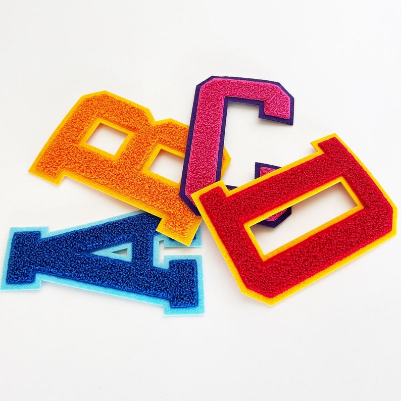 May include: Four felt letters, A, B, C, and D, in different colors. The A is blue, the B is orange, the C is pink, and the D is red.