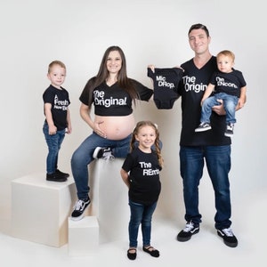 May include: A family of five wearing black t-shirts with white text. The shirts say "The Original", "A Fresh New Beat", "The Remix", "The Encore", and "Mic Drop".
