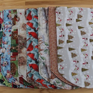 May include: A set of 10 Christmas tree skirts in various holiday patterns, including snowmen, cardinals, and reindeer. The skirts are made of fabric and have a scalloped edge.
