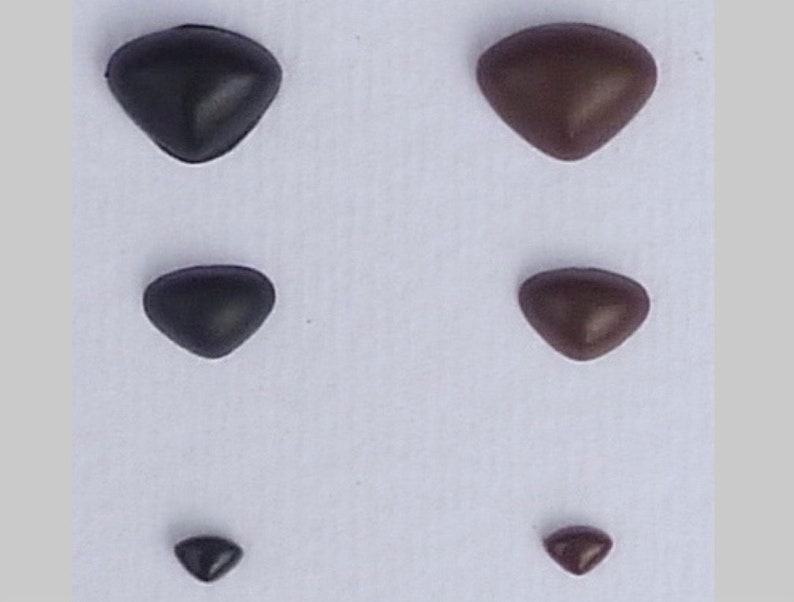May include: Five pairs of plastic safety eyes in different sizes. The eyes are black and brown and have a triangular shape.