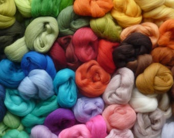 May include: A collection of colorful wool roving in various shades, including green, blue, red, orange, purple, and brown. The wool is arranged in a random pattern, creating a visually appealing display.