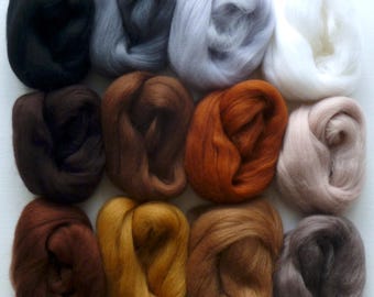 May include: Twelve balls of wool in various shades of brown, gray, and white. The balls are arranged in a grid pattern on a white surface. The word "Animal" is printed in black at the bottom of the image.