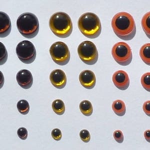 Puede incluir: Surtido de ojos de mu&ntilde;eca de pl&aacute;stico en varios tama&ntilde;os y colores, incluyendo negro, marr&oacute;n, dorado y naranja.