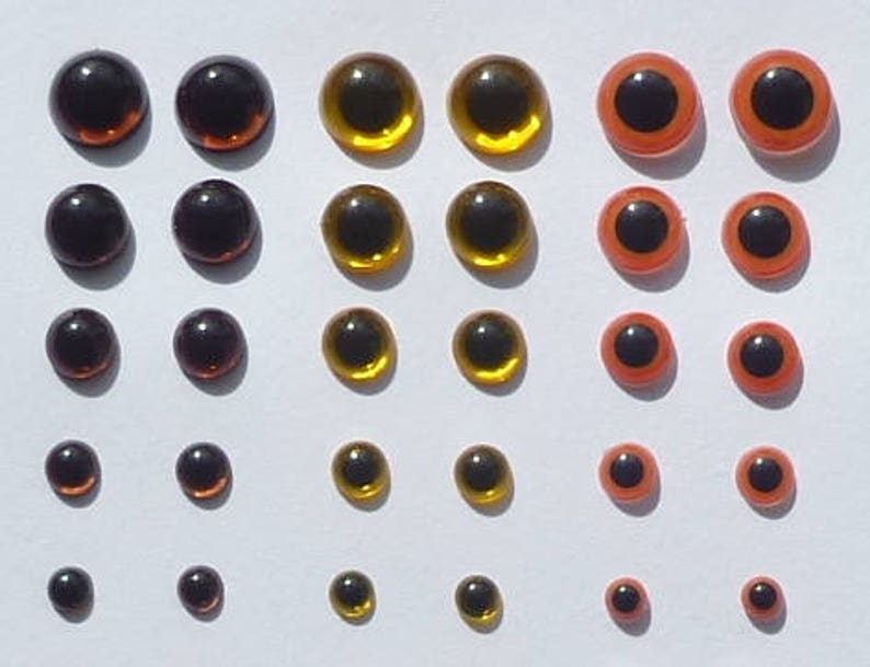 Puede incluir: Surtido de ojos de mu&ntilde;eca de pl&aacute;stico en varios tama&ntilde;os y colores, incluyendo negro, marr&oacute;n, dorado y naranja.