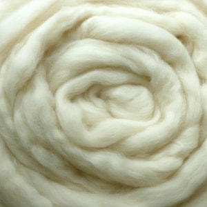 May include: A close-up of a white, fluffy, and soft material, resembling a cloud or a ball of cotton.