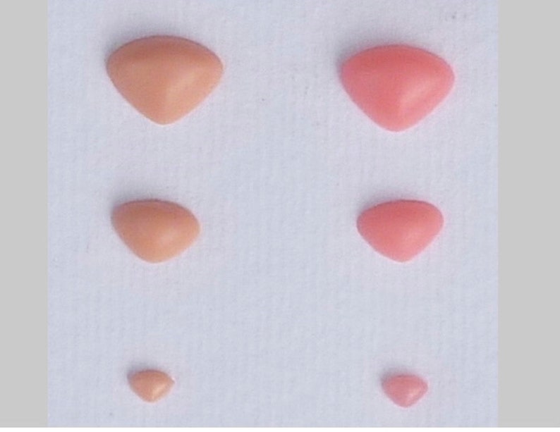May include: Five different sizes of pink and peach colored triangle shaped fabric patches.