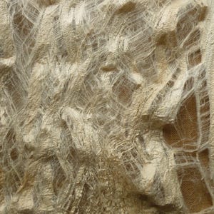 Pode incluir: Close-up de um tecido texturizado branco sujo com uma aparência desgastada e desfiada. O tecido tem um efeito em camadas, com fios e aberturas visíveis, criando uma textura artística única. O fundo é um castanho suave.