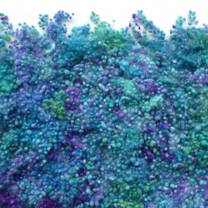 Può includere: Primo piano di una superficie testurizzata realizzata con filato blu, verde e viola. Il filato è disposto in modo casuale, creando una texture unica e colorata.