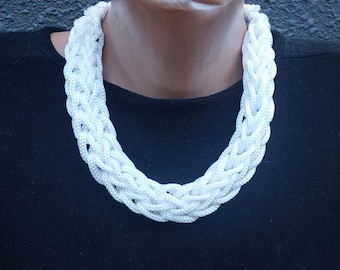 May include: A white crocheted necklace with a thick, braided design.