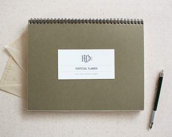May include: A green spiral bound perpetual planner with a white label that says "HD Co. Perpetual Planner" and "week, month, and part of a glance".