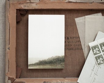 May include: A landscape painting of a misty forest and water, mounted in a wooden frame. Vintage stamps and envelopes are placed nearby. The artwork's dimensions are not visible. The painting is on canvas.