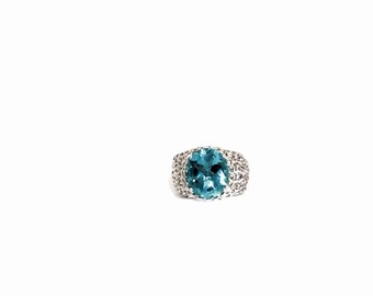 May include: A silver ring with a large, oval-shaped blue gemstone set in the center.