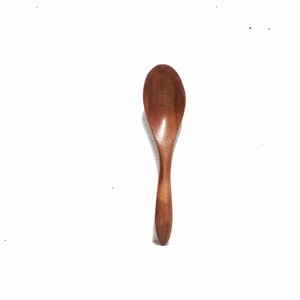 May include: A wooden spoon with a brown finish. The spoon is made of natural wood and has a smooth, rounded shape.