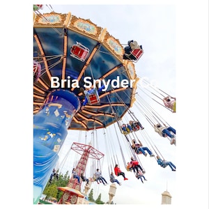 May include: A blue and gold carousel with red seats and people riding. The carousel is in motion and the people are swinging back and forth. The text "Bria Snyder" is visible on the carousel.