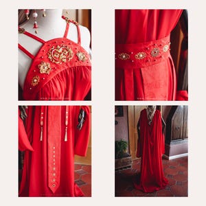 Puede incluir: Un vestido rojo vibrante con adornos dorados. El vestido presenta un cuello halter, un cintur&oacute;n decorativo y un dise&ntilde;o largo y fluido. Los detalles dorados incluyen patrones florales y ornamentados. El sitio web www.janinagold.com es visible.
