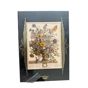 May include: A framed botanical print featuring a vibrant floral arrangement in a decorative urn. The print showcases a variety of colorful flowers, including sunflowers and other blooms. The frame is black with gold accents and the text "OPTIMAGO" is visible.