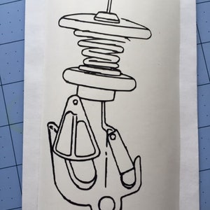 May include: A black and white line drawing of a boat cleat with a spring-loaded mechanism. The cleat is designed to secure a rope or line.
