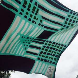A vintage Maggy Rouff silk scarf, in turquoise and black with hand-rolled corners