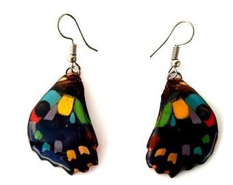 May include: A pair of colorful butterfly wing earrings. The wings are painted with a variety of colors, including red, yellow, green, blue, and purple. The earrings are made of metal and have a silver finish.