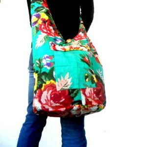 May include: A large, floral print, turquoise and red,  shoulder bag with a single strap. The bag has a small pocket on the front.