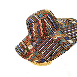 Puede incluir: Un sombrero de ala ancha para el sol con un estampado geom&eacute;trico colorido. El sombrero est&aacute; hecho de tejido tejido y tiene una corona plana.