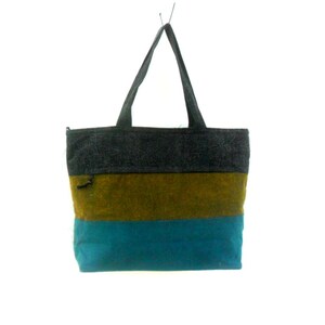 May include: A striped tote bag with a dark grey top, a brown middle section, and a teal blue bottom. The bag has two black straps.