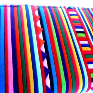 Puede incluir: Una tela de rayas coloridas con una variedad de colores, incluyendo rojo, azul, verde, amarillo y rosa. La tela est&aacute; hecha de m&uacute;ltiples tiras de tela cosidas juntas.