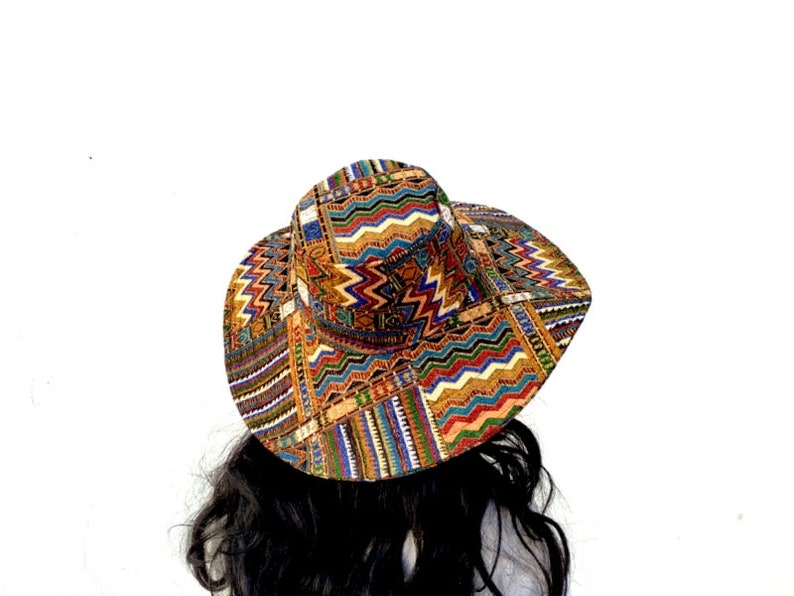 Puede incluir: Un sombrero de ala ancha con un estampado geom&eacute;trico colorido en tonos de marr&oacute;n, naranja, azul, verde y blanco.