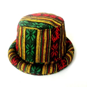 May include: A colorful bucket hat with a red, yellow, green, and black striped pattern. The hat has a flat top and a wide brim.