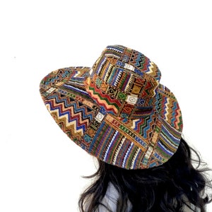 Puede incluir: Un sombrero de ala ancha con un estampado geom&eacute;trico colorido. El sombrero est&aacute; hecho de tejido tejido y tiene una corona plana.