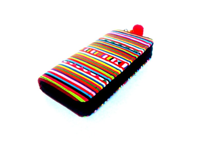 Puede incluir: Una cartera de rayas coloridas con una cremallera negra y un pomp&oacute;n rojo.