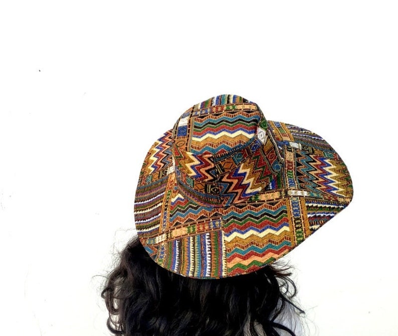 Puede incluir: Un sombrero de ala ancha con un estampado geom&eacute;trico colorido en tonos de rojo, naranja, amarillo, verde, azul y negro.