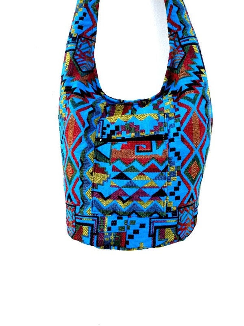 May include: A blue, red, yellow, and green patterned shoulder bag with a zippered pocket.
