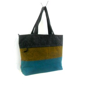 May include: A striped tote bag with a grey, brown, and teal colour scheme. The bag has two handles and a zip closure.