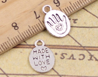 May include: Two silver charm pendants. One pendant features a handprint with a heart in the palm. The other pendant says "Made with Love" with a small heart.